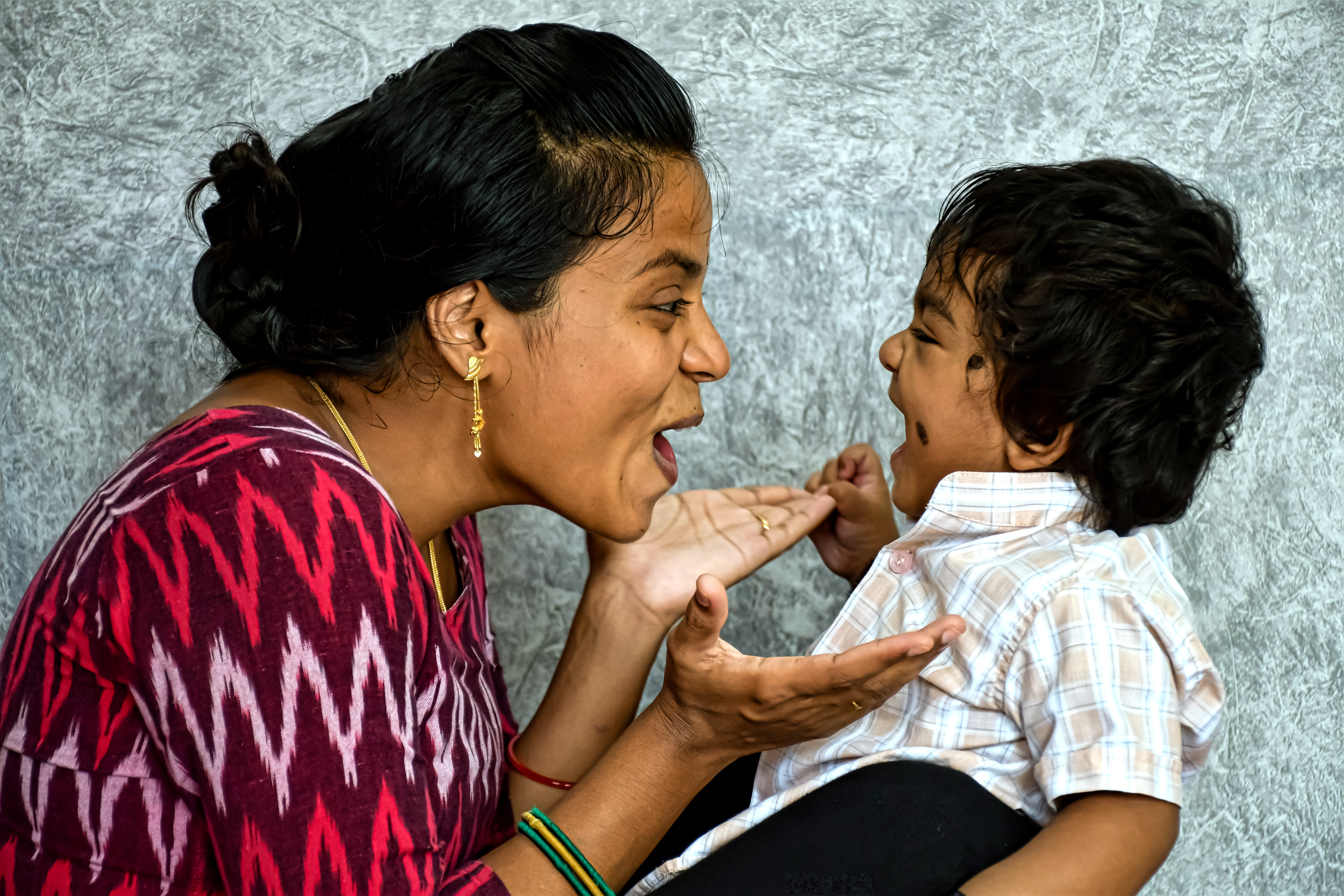 Eastern South Asian mother and son laughing